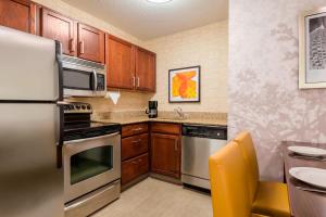 a kitchen with stainless steel appliances and wooden cabinets at Residence Inn Macon in Macon