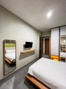 een slaapkamer met een bed en een spiegel bij CASA CALMA HOTEL in Jakarta