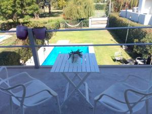 a table and chairs on a balcony with a pool at EL ENCUENTRO in Junín