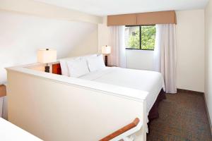 ein Hotelzimmer mit einem großen weißen Bett und einem Fenster in der Unterkunft Residence Inn Minneapolis Eden Prairie in Eden Prairie