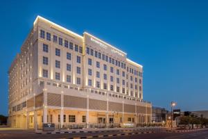 Residence Inn by Marriott Dammam في الدمام: مبنى ابيض كبير على جانب شارع