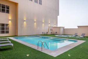 Residence Inn by Marriott Dammam في الدمام: مسبح على جانب مبنى