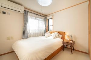 1 dormitorio con cama y ventana en Ikebukuro house with 5BR Free Parking, en Tokio