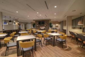 un restaurant avec des tables, des chaises et une cheminée dans l'établissement Fairfield Inn & Suites by Marriott Gatlinburg Downtown, à Gatlinburg