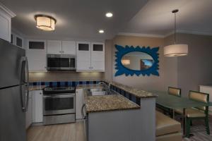 a kitchen with white cabinets and a table with a dining room at Marriott's OceanWatch Villas at Grande Dunes in Myrtle Beach