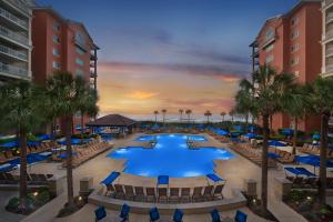 eine Aussicht über den Pool des Resorts mit Stühlen und Palmen in der Unterkunft Marriott's OceanWatch Villas at Grande Dunes in Myrtle Beach