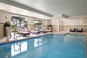 una piscina en un hotel con sillas y mesas en SpringHill Suites Austin South, en Austin