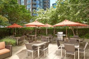 a patio with tables and chairs and umbrellas at Residence Inn by Marriott Vancouver Downtown in Vancouver