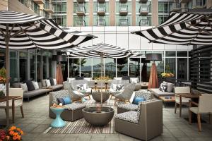 un patio con sedie, tavoli e ombrelloni di Seattle Marriott Waterfront a Seattle