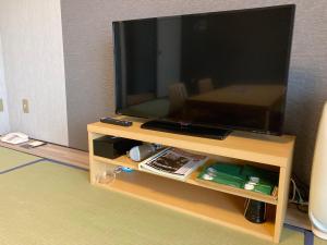 a flat screen tv sitting on top of a wooden stand at Route Inn Grantia Fukuoka Miyawaka - Wakita Onsen in Miyawaka