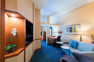 a hotel room with a couch and a tv and a desk at Fairfield Inn & Suites Marianna in Marianna