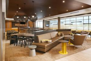 a lobby with a couch and chairs and a restaurant at SpringHill Suites Dallas DFW Airport South/CentrePort in Fort Worth