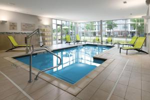 a large swimming pool with yellow chairs and chairs at SpringHill Suites Dallas DFW Airport South/CentrePort in Fort Worth