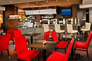 スターリングにあるCourtyard by Marriott Dulles Town Centerの赤い椅子とバーのあるレストラン