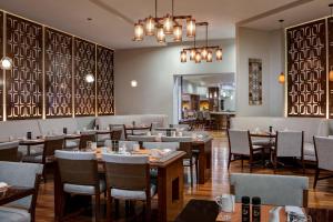 uma sala de jantar com mesas e cadeiras de madeira em Marriott Albuquerque em Albuquerque