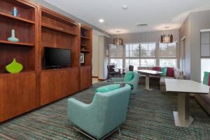 a living room with green chairs and a flat screen tv at Residence Inn by Marriott Baton Rouge near LSU in Baton Rouge
