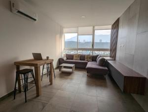 een woonkamer met een bank en een tafel bij Stylish Panoramic Views City Loft in Monterrey