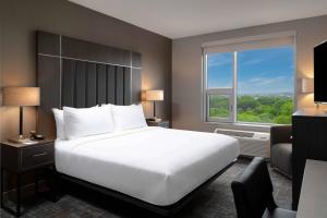 a bedroom with a large bed and a large window at Fairfield by Marriott Inn & Suites Boston Medford in Medford