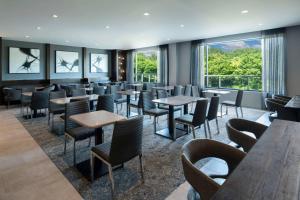 a restaurant with tables and chairs and windows at Fairfield by Marriott Inn & Suites Boston Medford in Medford