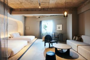 um quarto de hotel com duas camas e uma mesa em Korinkyo em Kanazawa