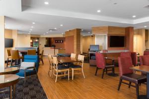 a restaurant with tables and chairs and a kitchen at Towneplace Suites By Marriott Austin North/Lakeline in Cedar Park