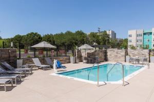 a pool at a hotel with lounge chairs and tables at Towneplace Suites By Marriott Austin North/Lakeline in Cedar Park