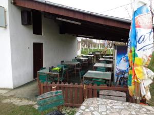 eine Gruppe von Tischen und Stühlen außerhalb eines Gebäudes in der Unterkunft Gasthaus Enduro Bica in Caransebeş