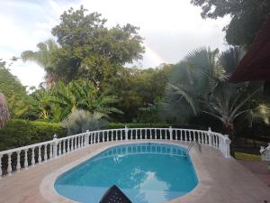 einen Pool mit einem weißen Zaun um ihn herum in der Unterkunft FINCA-CASA DE DESCANSO GUAMO TOLIMA in Guamo