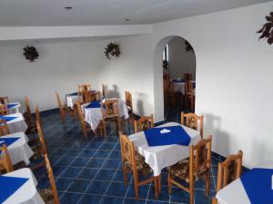 uma sala de jantar com mesas e cadeiras e um espelho em Gasthaus Enduro Bica em Caransebes