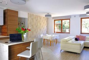 een woonkamer met een witte bank en een tafel bij Urban Jungle Garden & Patio - Luksusowy apartament w Gdyni in Gdynia