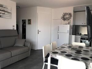 kuchnia i jadalnia ze stołem i kanapą w obiekcie Appartement moderne, climatisé, quartier calme, proche commodités, avec parking privatif - FR-1-723-17 w Cap d'Agde +2 zdjęcia