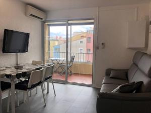 salon ze stołem, kanapą i telewizorem w obiekcie Appartement moderne, climatisé, quartier calme, proche commodités, avec parking privatif - FR-1-723-17 w Cap d'Agde