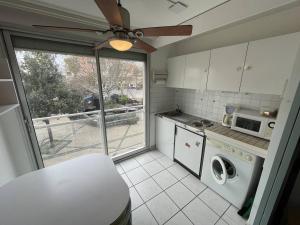 eine kleine Küche mit einer Mikrowelle und einem Fenster in der Unterkunft Studio Cap d'Agde, 1 pièce, 3 personnes - FR-1-723-41 in Cap d'Agde