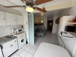 eine Küche mit einer Waschmaschine, einem Trockner und einer Mikrowelle in der Unterkunft Studio Cap d'Agde, 1 pièce, 3 personnes - FR-1-723-41 in Cap d'Agde