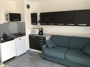 een woonkamer met een blauwe bank in een keuken bij Studio Cap d'Agde, 2 pièces, 4 personnes - FR-1-723-28 in Cap d'Agde