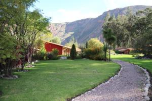 a garden with a stone path leading to a house at Hotel Villa Urubamba in Urubamba