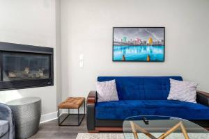 uma sala de estar com um sofá azul e uma televisão em Luxury 4BR 3Bath 2KSQFT Sleeps 10 Pet Friendly Nice Backyard, City Views and 2 Car Garage em Pittsburgh