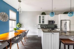a kitchen with a table and a clock on the wall at Family-Friendly 4BR Retreat Sleeps 12, Private Yard, Garage, Close to Stadiums, Casino & Downtown in Pittsburgh