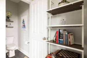 a bathroom with a toilet and a shelf with books at Family-Friendly 4BR Retreat Sleeps 12, Private Yard, Garage, Close to Stadiums, Casino & Downtown in Pittsburgh +71 photos