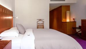 um quarto com uma cama branca e um armário de madeira em Camino Real Polanco Mexico em Cidade do México