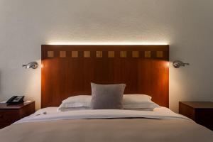 um quarto com uma cama grande e uma cabeceira em madeira em Camino Real Polanco Mexico em Cidade do México