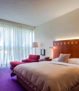 a bedroom with a large bed and a red chair at Camino Real Polanco Mexico in Mexico City