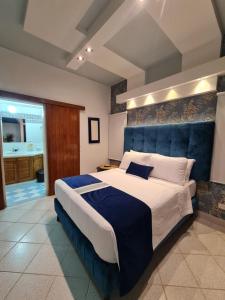 um quarto com uma cama grande e uma cabeceira azul em Casa Blanca del Mar em Santa Marta