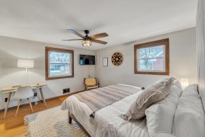 a bedroom with a bed and a desk and a ceiling fan at Titletown Hideaway- Spacious BoHo home in Green Bay