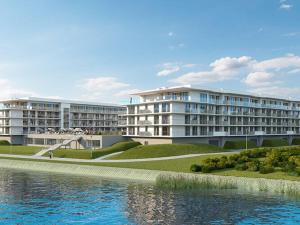 a large building next to a body of water at Apartment in Dziwnów by the River & Beach in Dziwnów