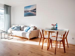 a living room with a couch and a table at Comfortable apartment, swimming pool, sauna, fitness, Dziwnów in Dziwnów