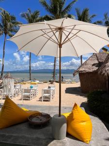 a white umbrella and some yellow objects on the beach at Sea Love Beach Bar & Bungalows in Ban Tai