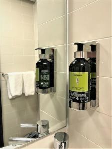 een badkamer met een spiegel en een fles shampoo bij Haven Glebe in Sydney