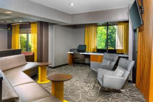 a hotel room with a waiting area with chairs and a desk at SpringHill Suites Asheville in Asheville