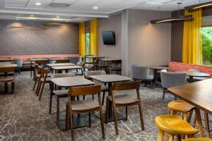 a dining room with tables and chairs and a tv at SpringHill Suites Asheville in Asheville